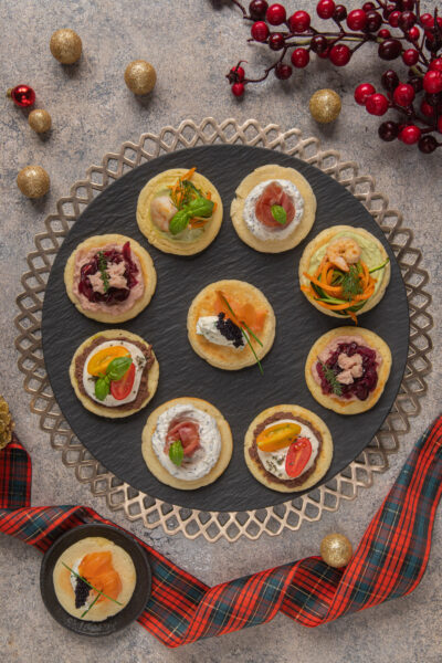 Un antipasto di origine russa, composto da piccoli pancakes dal sapore neutro con diverse farciture colorate