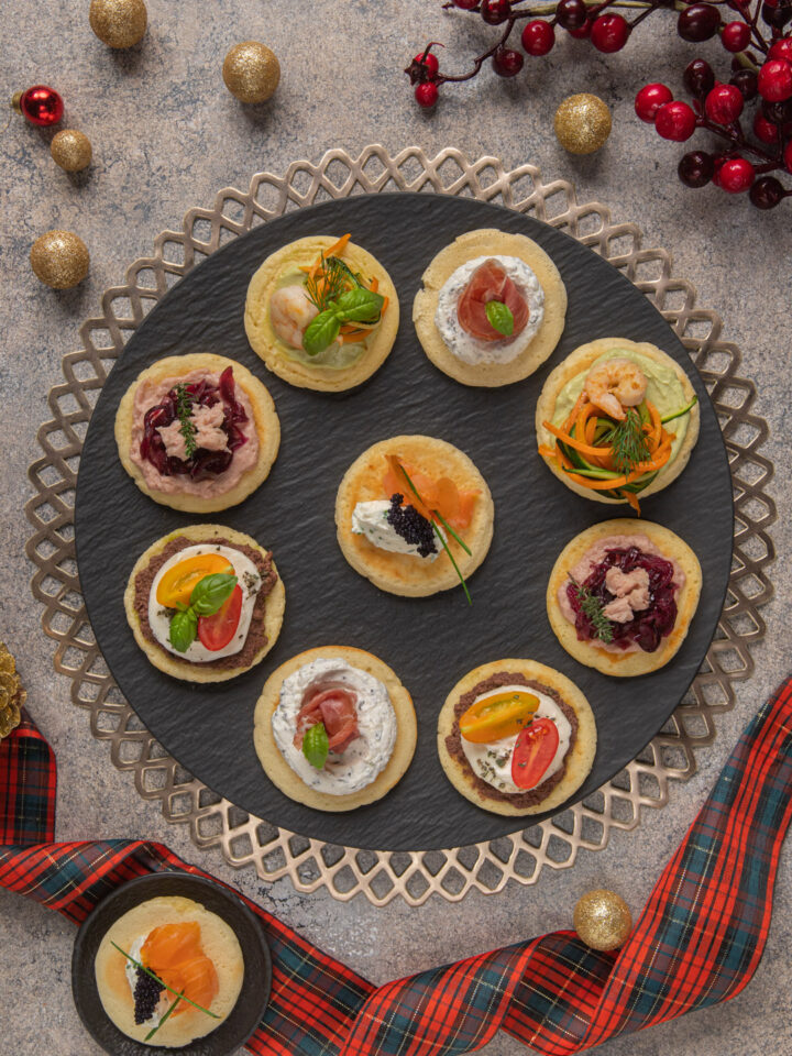 Un antipasto di origine russa, composto da piccoli pancakes dal sapore neutro con diverse farciture colorate