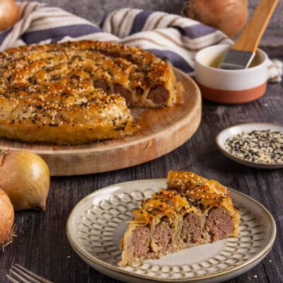 Una torta salata di origine turca a base di pasta fillo farcita con carne macinata di manzo e cipolla, cosparsa di sesamo e cotta in forno