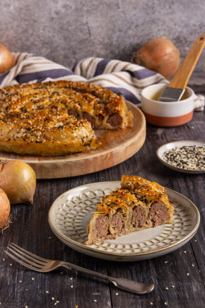 Una torta salata di origine turca a base di pasta fillo farcita con carne macinata di manzo e cipolla, cosparsa di sesamo e cotta in forno