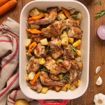 Coniglio, cipolle, carote, patate e il calore del forno: il risultato è un piatto semplice, dal sapore delicato ma anche molto soddisfacente