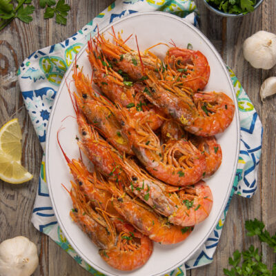 I gamberoni in padella sono un piatto di mare semplice ma gustoso, in cui questi crostacei sono cotti brevemente e conditi con prezzemolo e limone
