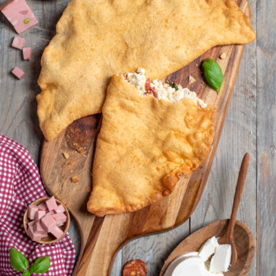 La pizza fritta è una versione ancora più golosa del celebre street food napoletano, che si prepara con il tradizionale impasto della pizza, che viene farcito, richiuso su se stesso e fritto. Provalo con ricotta, mozzarella, mortadella e salamino piccante!