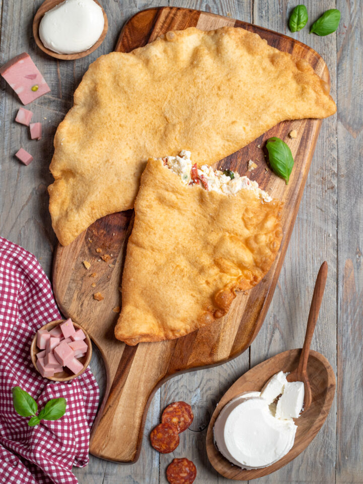 La pizza fritta è una versione ancora più golosa del celebre street food napoletano, che si prepara con il tradizionale impasto della pizza, che viene farcito, richiuso su se stesso e fritto. Provalo con ricotta, mozzarella, mortadella e salamino piccante!
