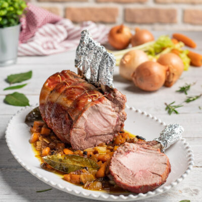 L'arista di maiale al forno, servita intera con il suo fondo profumato alle erbe aromatiche e la sua glassatura al miele è un secondo piatto succulento adatto anche alle Feste