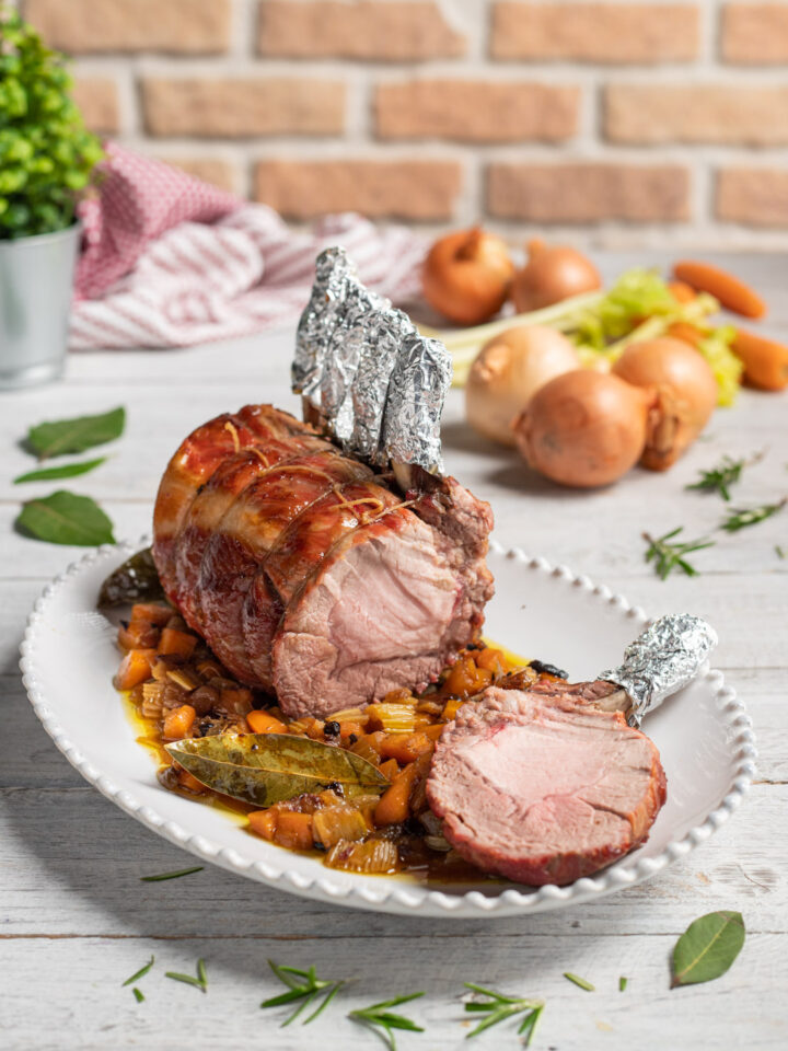 L'arista di maiale al forno, servita intera con il suo fondo profumato alle erbe aromatiche e la sua glassatura al miele è un secondo piatto succulento adatto anche alle Feste