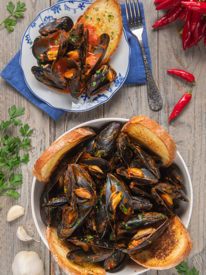 Le cozze alla tarantina sono un delizioso antipasto pugliese, in cui questo saporito mollusco viene condito con una salsa al pomodoro piccante, in cui intingere il rustico pane di Altamura