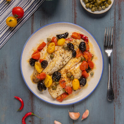 I filetti di orata all'isolana sono un secondo piatto che racchiude il sapore del mare e dei più classici ingredienti mediterranei: olive, pomodorini, capperi, aglio origano e peperoncino