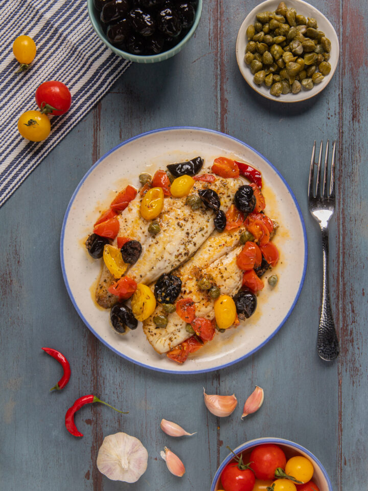 I filetti di orata all'isolana sono un secondo piatto che racchiude il sapore del mare e dei più classici ingredienti mediterranei: olive, pomodorini, capperi, aglio origano e peperoncino