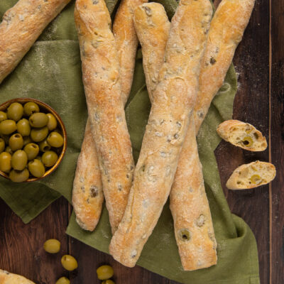 I filoncini alle olive sono un lievitato saporito ideale da presentare nel cestino del pane, in cui al gusto neutro dell'impasto vengono aggiunge le olive per una spinta di sapore in più