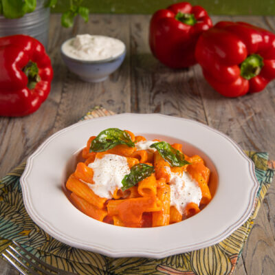 Un primo piatto colorato e fresco, ideale per la bella stagione e semplice da preparare, con peperoni arrostiti e poi ridotti in una crema vellutata e a completare stracciatella e basilico fritto