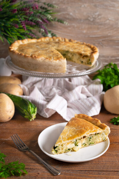 La torta salata con zucchine, patate e scamorza è un involucro pasta brisée farcito con un ripieno vegetariano ma delizioso