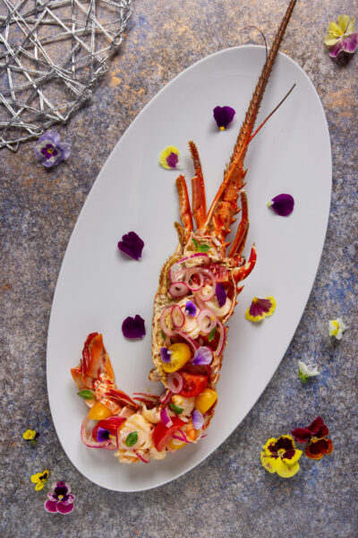 Un antipasto o secondo piatto di pesce raffinato, ideale per Natale, Capodanno o San Valentino, a base di aragosta, pomodorini, cipolla e citronette