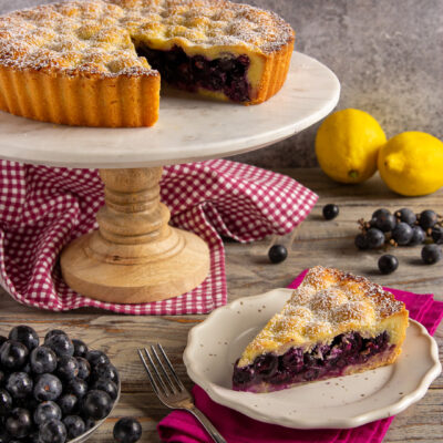 La crostata di uva fragola è una torta deliziosa a base di pasta frolla con un ripieno di biscotti sbriciolati e un frutto molto particolare il cui aroma che ricorda proprio quello del frutto rosso simbolo dell'estate