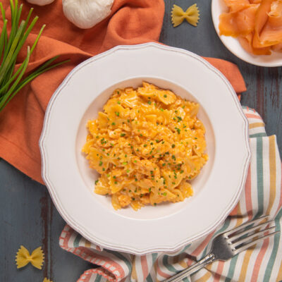 Un piatto anni Ottanta che non possa mai di moda. Veloce e facile da preparare prevede solo pasta, salmone affumicato, panna e concentrato di pomodoro
