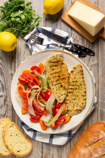 Cotoletta Palermitana è cotta alla piastra o al forno e impreziosita da un mix aromatico di erbe e pangrattato.