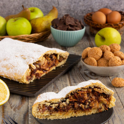 Strudel di frolla con mele, pere, noci. Un dessert irresistibile che combina la dolcezza della frutta fresca con la golosità del cioccolato fondente e la croccantezza delle noci.