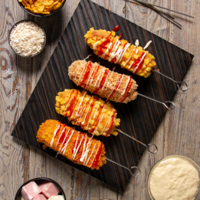 Korean corn dog di mortadella Un particolare hot dog di mortadella e provola avvolte in una pastella lievitata e racchiuse in una croccante panatura