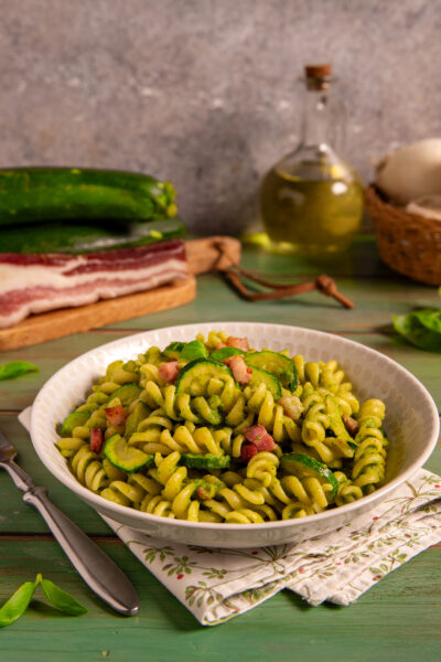 Pasta zucchine e pancetta un piatto in cui il basilico fresco e la pancetta croccante danno sapore e aroma alla ricetta.