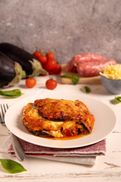 Pasticcio di melanzane Piatto al forno con melanzane arrostite, sugo di carne, formaggi filanti e besciamella.