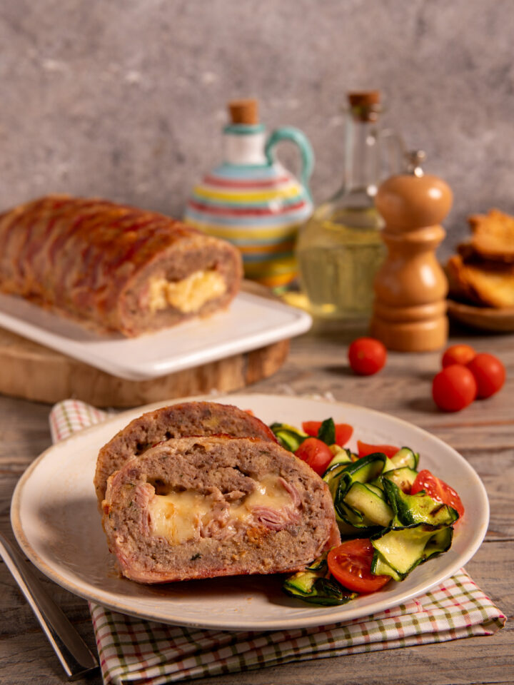 Polpettone di carne vestito Polpettone al forno con involucro di bacon, cuore filante di provola e fontina e impasto ricco di sapori.