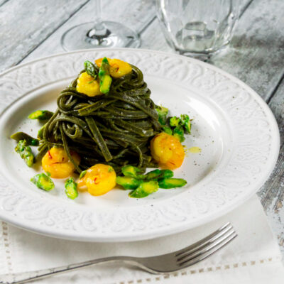 Tagliolini al nero di seppia con gamberetti asparagi e zafferano un piatto elegante e saporito che sa di mare.