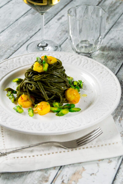 Tagliolini al nero di seppia con gamberetti asparagi e zafferano un piatto elegante e saporito che sa di mare.