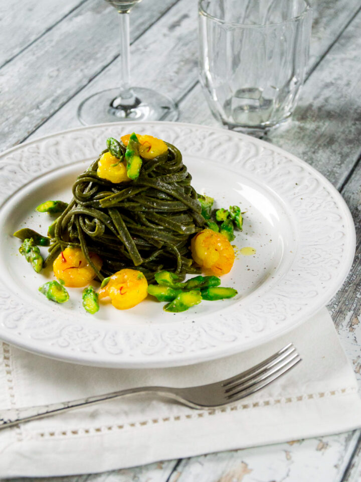 Tagliolini al nero di seppia con gamberetti asparagi e zafferano un piatto elegante e saporito che sa di mare.